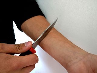 Wikimedia Commons: Self Harming With a Knife by Santari Viinamaki, CC Attribution/Share Alike 4.0 International
