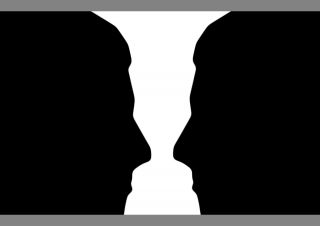 Does this image show silhouettes in profile or a white vase?