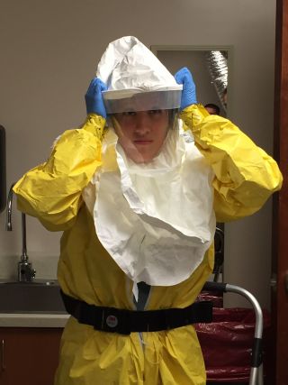 A nurse demonstrates how to wear protective equipment when treating a patient with Ebola.