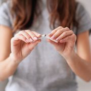 Woman breaks cigarette in half. Gorynvd/Shutterstock