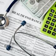 Health insurance forms, calculator, and stethoscope 
