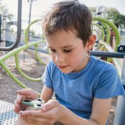 Boy with autism holding fidget spinner on playground