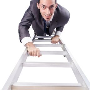 Man in business suit climbing a ladder