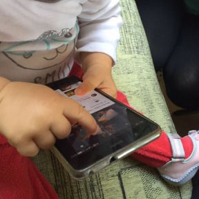 婴儿拿着iPhone的手