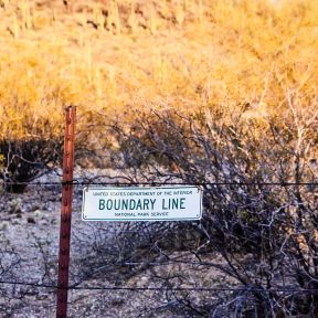 Fence with boundary line sign.