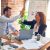 Man and woman high-five over a desk.