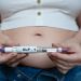Woman holding a GLP-1 injection pen. 