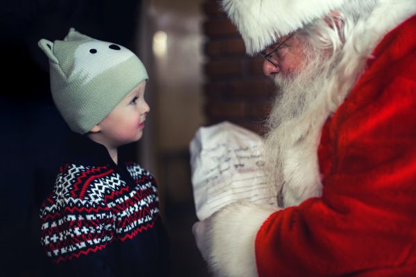 Young child receiving a gift from Santa Claus. 