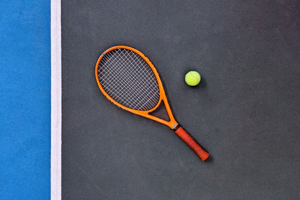 Tennis racket laying on tennis court