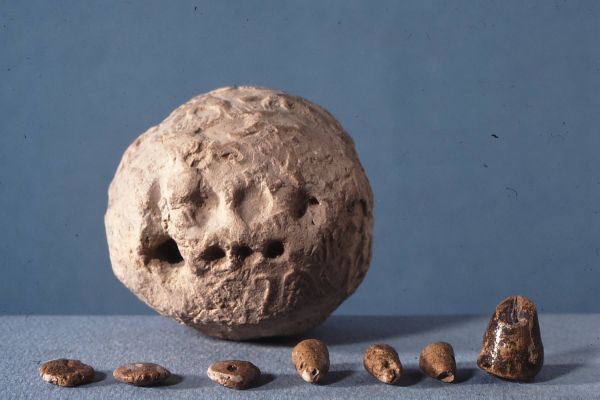 Envelope and the tokens it held, from Susa, Iran, ca. 3300 BC. The tokens stand for commodities like animals and grain