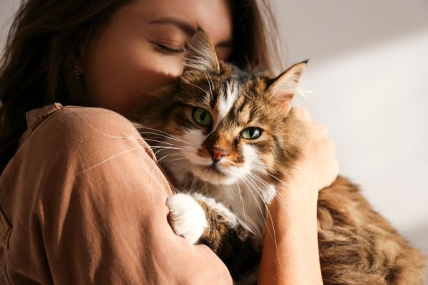 Young woman cuddling a cat.